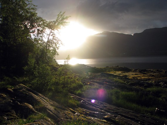 Die Sonne lugt durch die dicken schwarzen Wolken